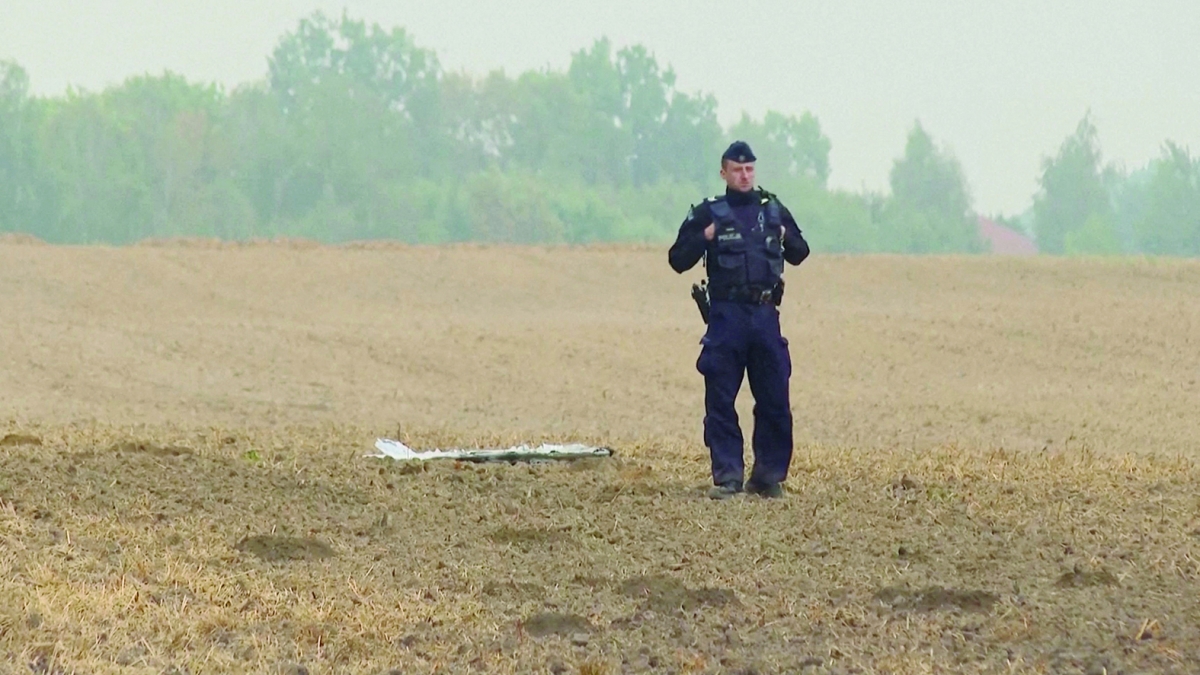 ضابط شرطة قرب شظية طائرة مُسيرّة سقطت شرق بولندا (أ ف ب)