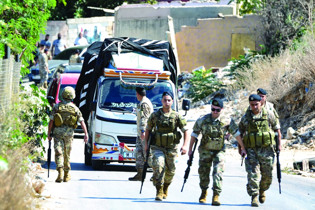 جنود من الجيش أمام شاحنة أسلحة داخل مخيم البداوي (أ ف ب)