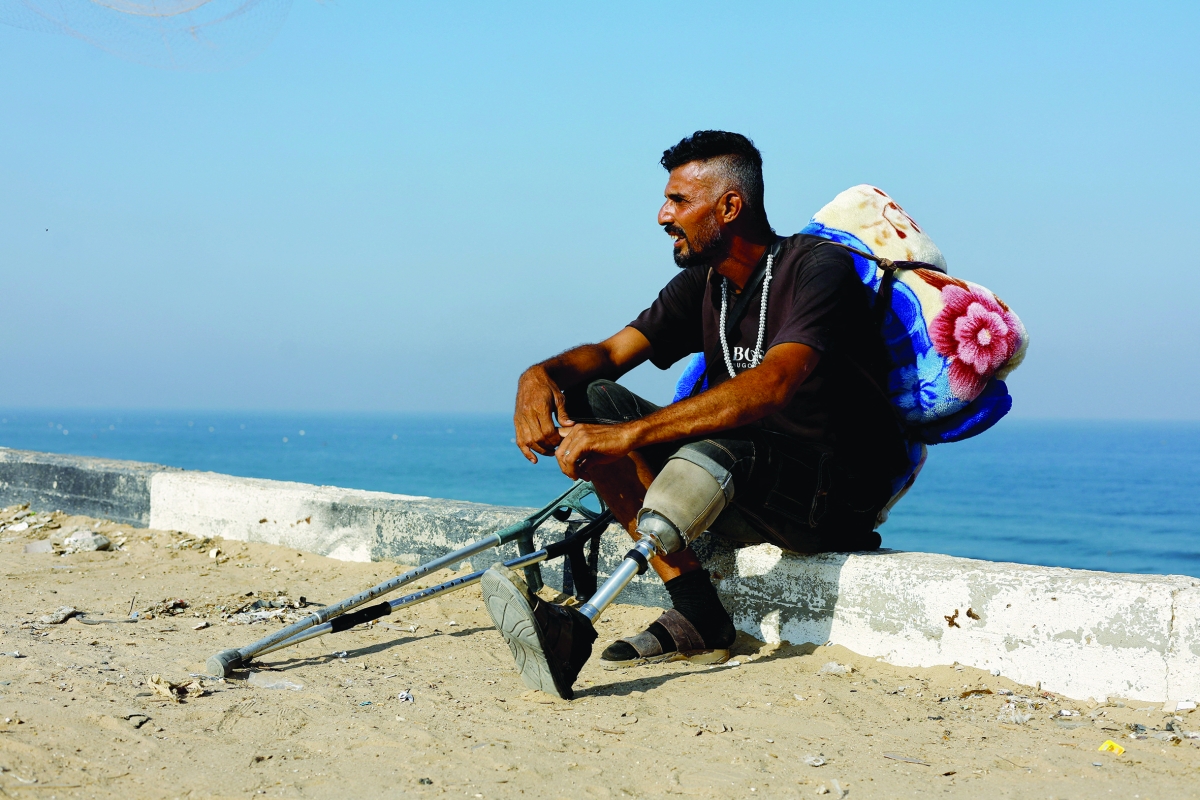 فلسطيني فقد ساقه في غارة إسرائيلية يستريح خلال فراره من شمال غزة (رويترز)