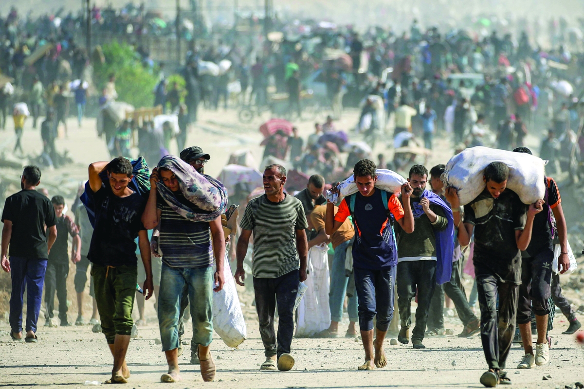 


فلسطينيون يحملون مساعدات في مخيم النصيرات للاجئين 	(أ ف ب) 