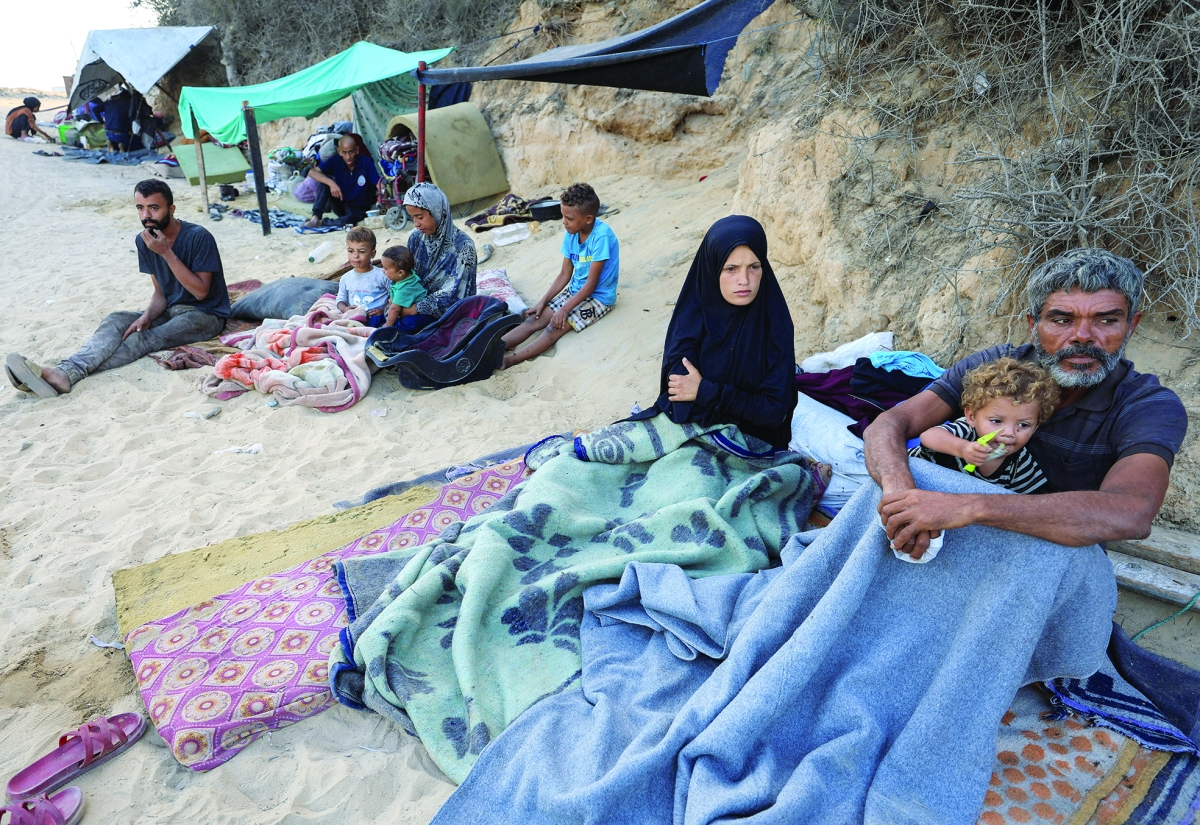 أسر فلسطينية تفترش الأرض خلال النزوح إلى جنوب غزة (رويترز)