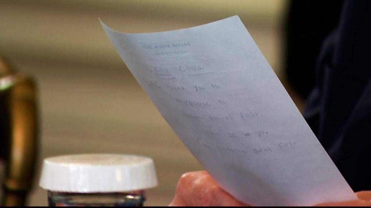 الإشعار المكتوب بخط اليد على ورق يحمل شعار البيت الأبيض الذي تم تمريره لترامب
