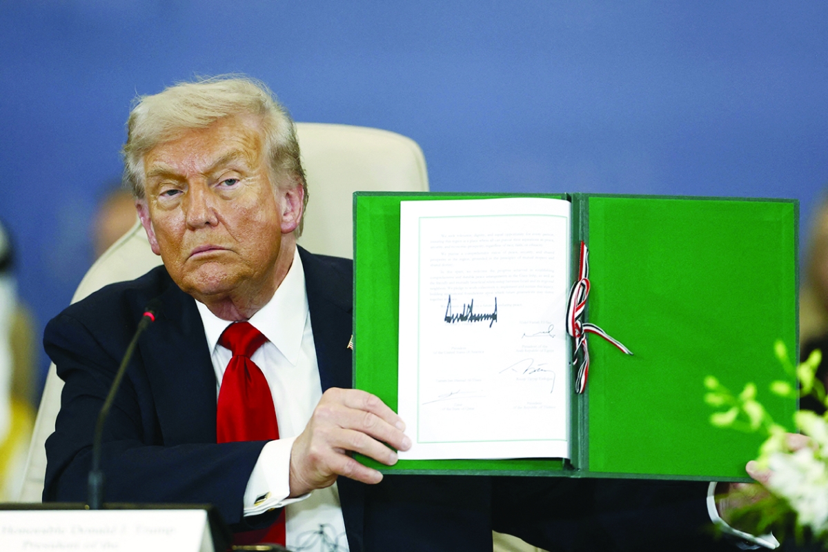 


ترامب يحمل وثيقة اتفاق غزة  	  (أف ب) 