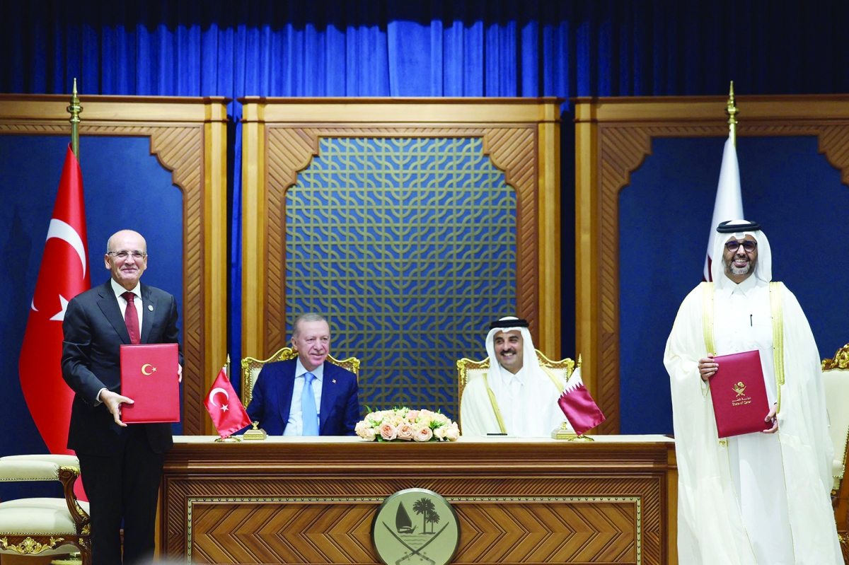 تميم بن حمد وأردوغان خلال توقيع اتفاقيات تعاون في الدوحة (أ ف ب)