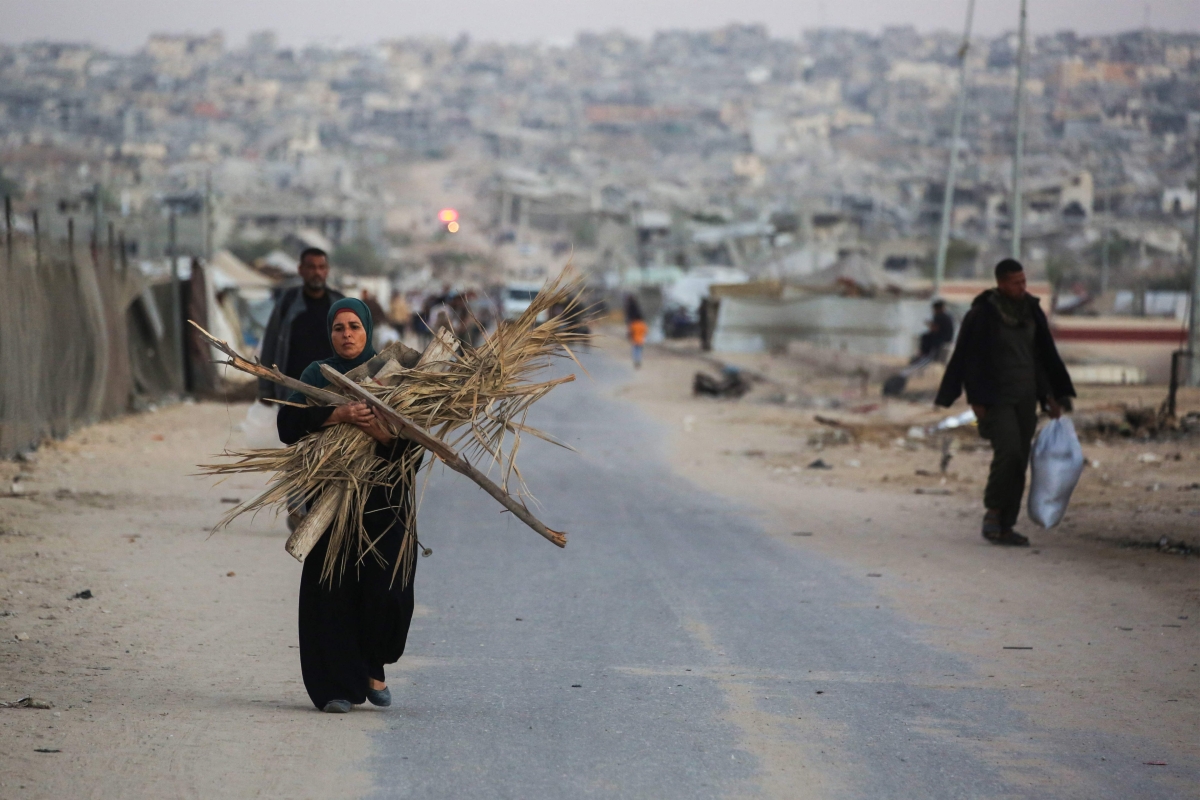 فلسطينية تحمل حَطباً لاستخدامه بالطهو في خان يونس (أ ف ب)