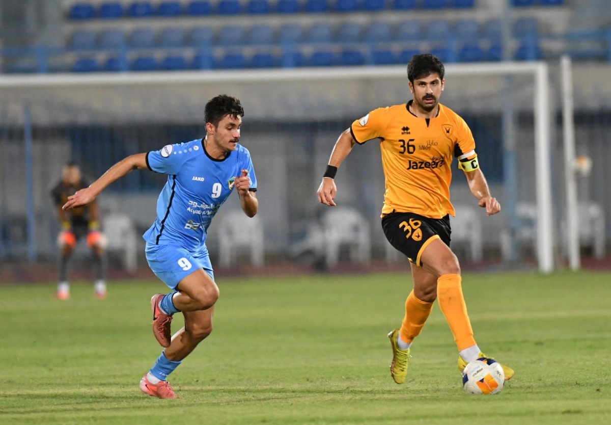 مدافع «الأصفر» خالد إبراهيم يبعد الكرة من أمام مهند المحاميد