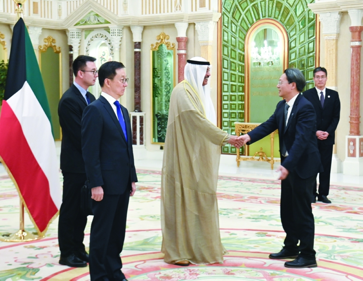 سمو ولي العهد مصافحاً أحد أعضاء الوفد الصيني على هامش مأدبة الغداء