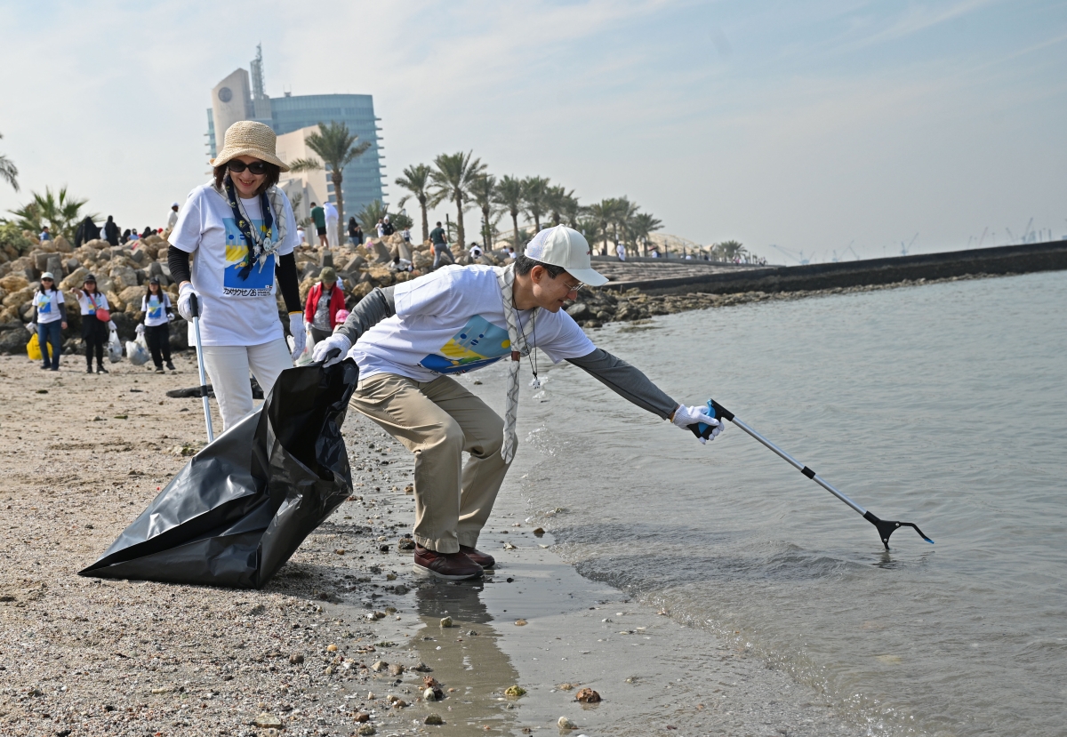 السفير الياباني يرفع مخلفات من شاطئ الشويخ (تصوير نايف العقلة)