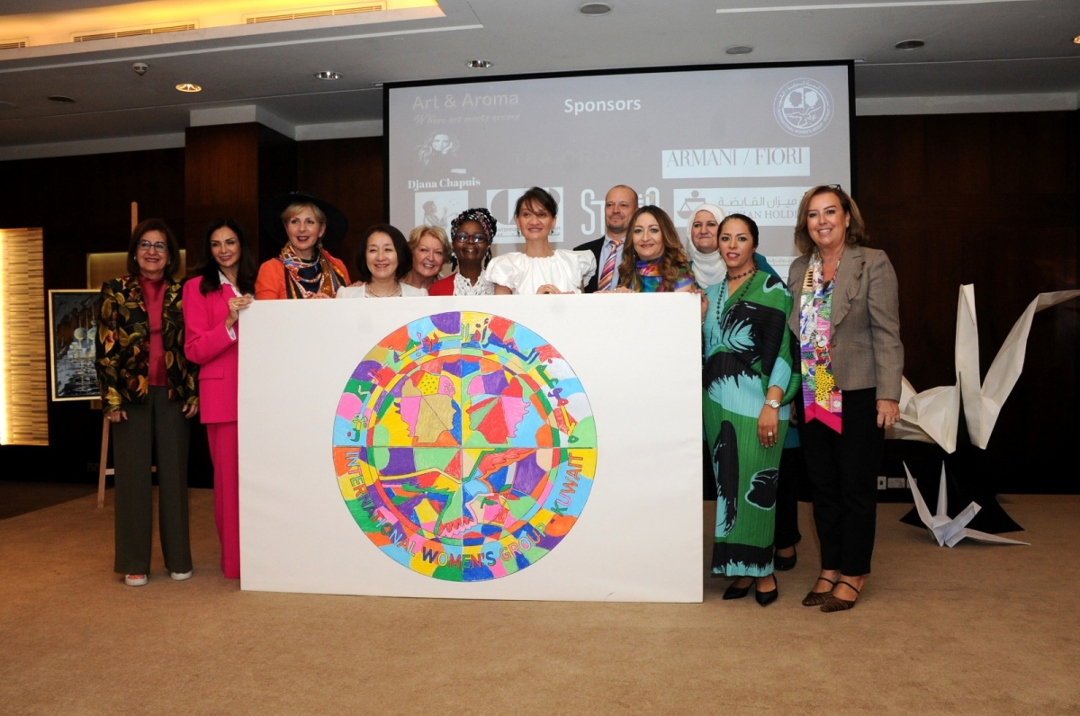 عضوات المرأة الدوية أمام لوحة شعار المجموعة