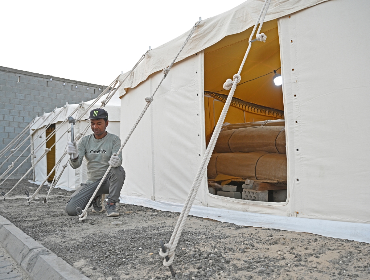 عامل يشد أوتاد الخيام في السوق