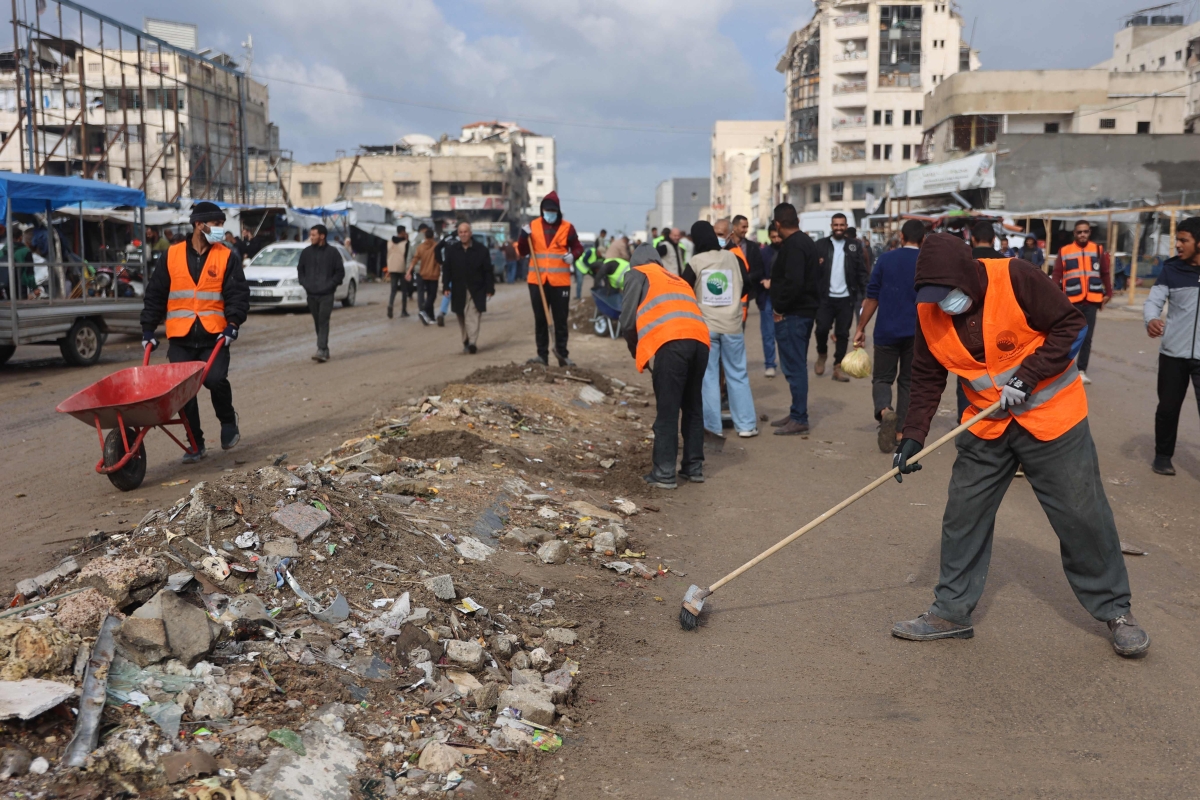 فلسطينيون يشاركون في حملة «سنعيد بناء غزة من جديد» (أ ف ب)
