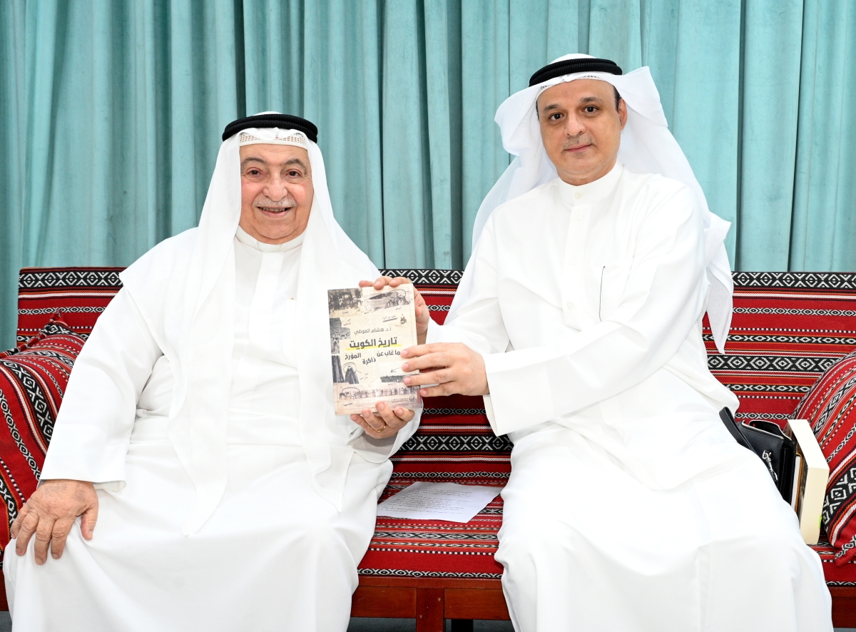 
العوضي وغريب يمسكان بالكتاب الجديد