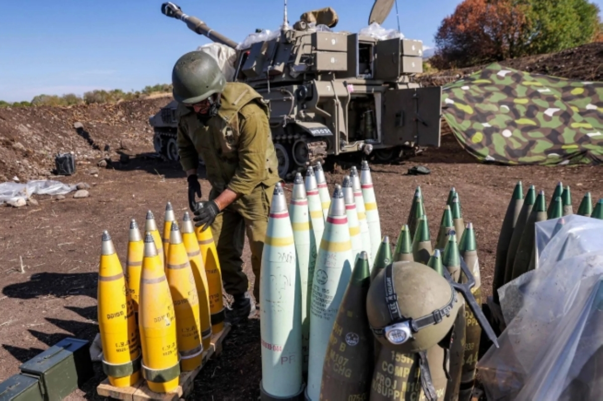 جندي إسرائيلي أمام قذائف صاروخية أميركية