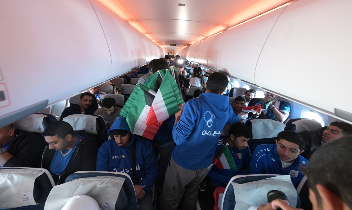 توزيع أعلام الكويت على المشاركين في الطائرة