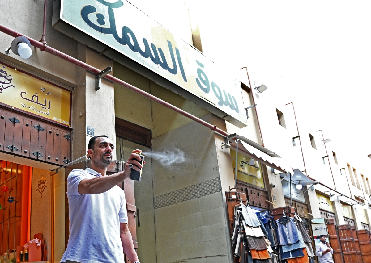 عامل يرش العطور أمام محله 