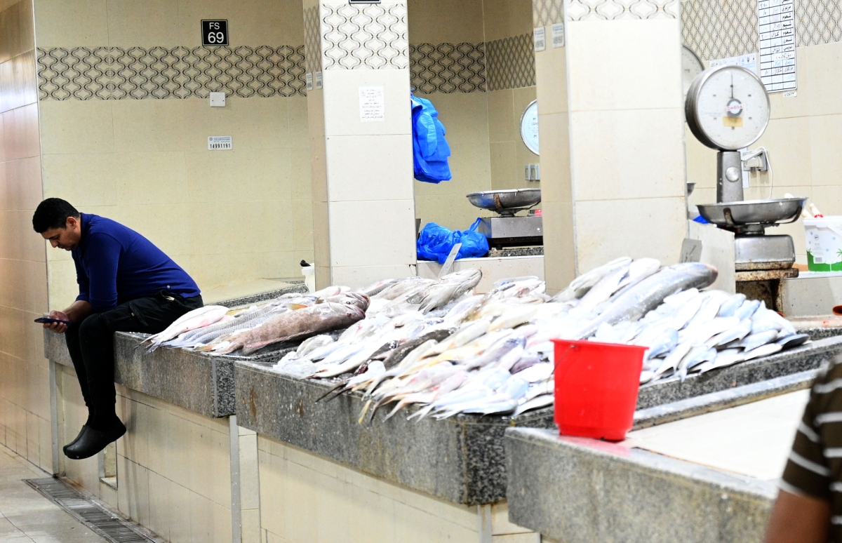 بائع يلهو بهاتفه في غياب الزبائن