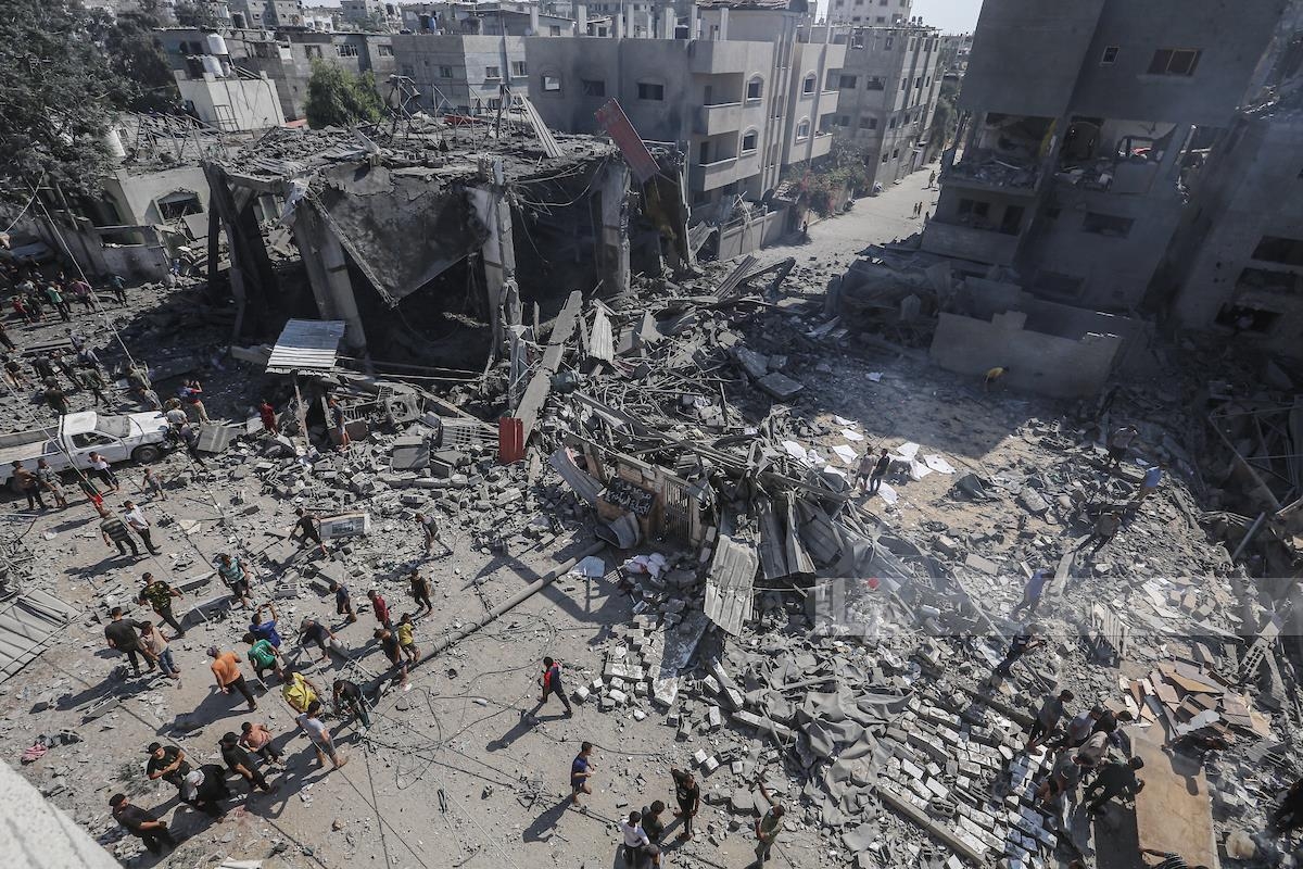 فلسطينيون في موقع غارة إسرائيلية على غزة