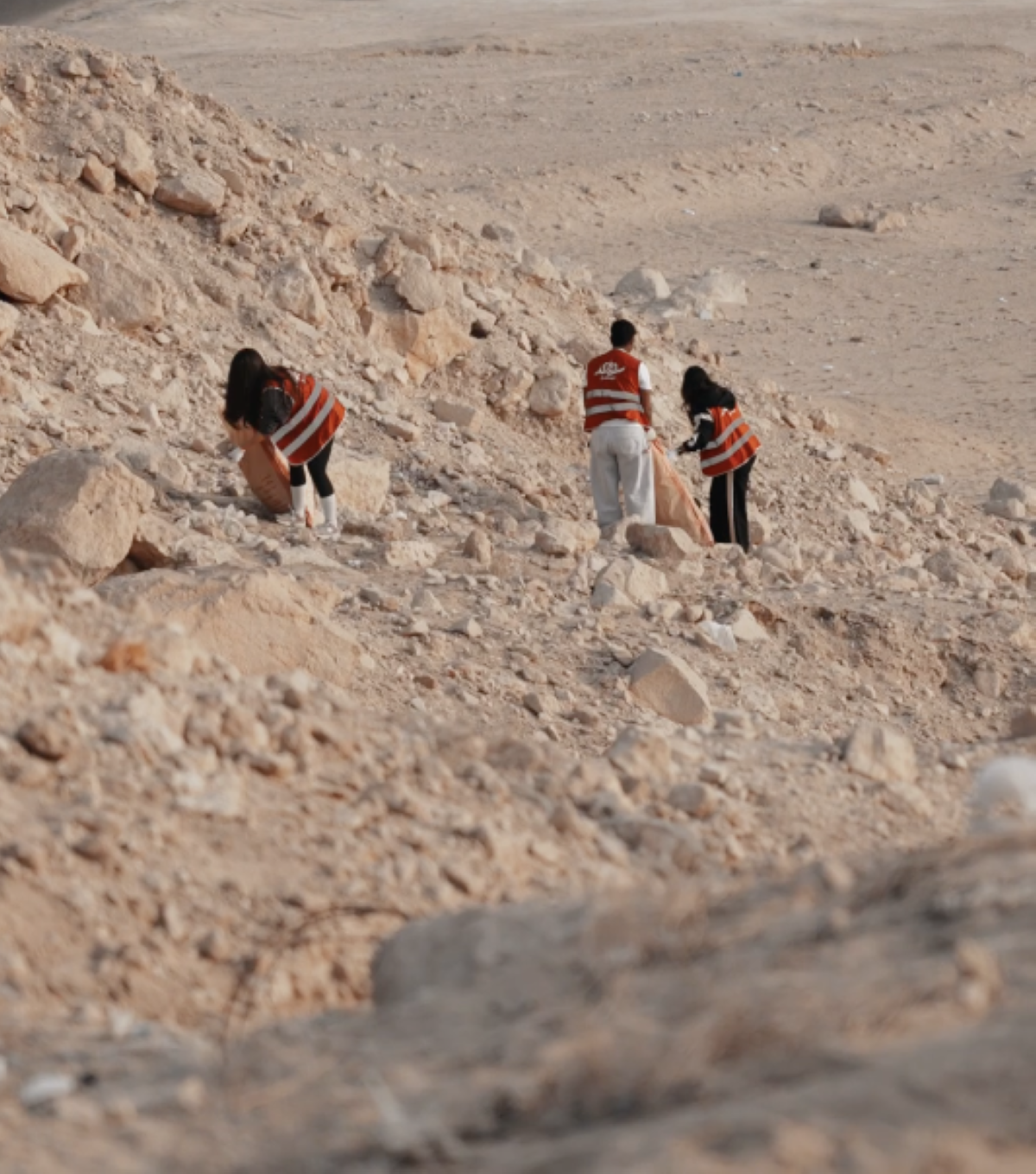 أعضاء فريق «سواعد الخليج» ينظفون المنطقة