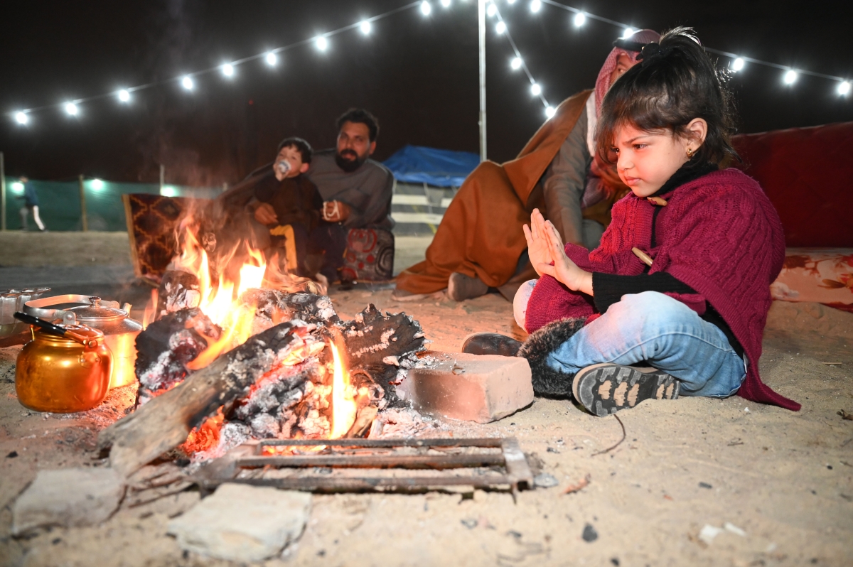 فتاة تتقي البرد بالاقتراب من النيران (تصوير نايف العقلة)