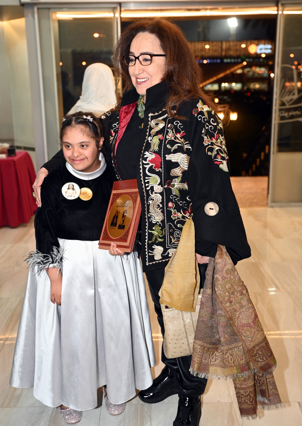 بيبي اليوسف تحتضن طفلة على هامش الندوة