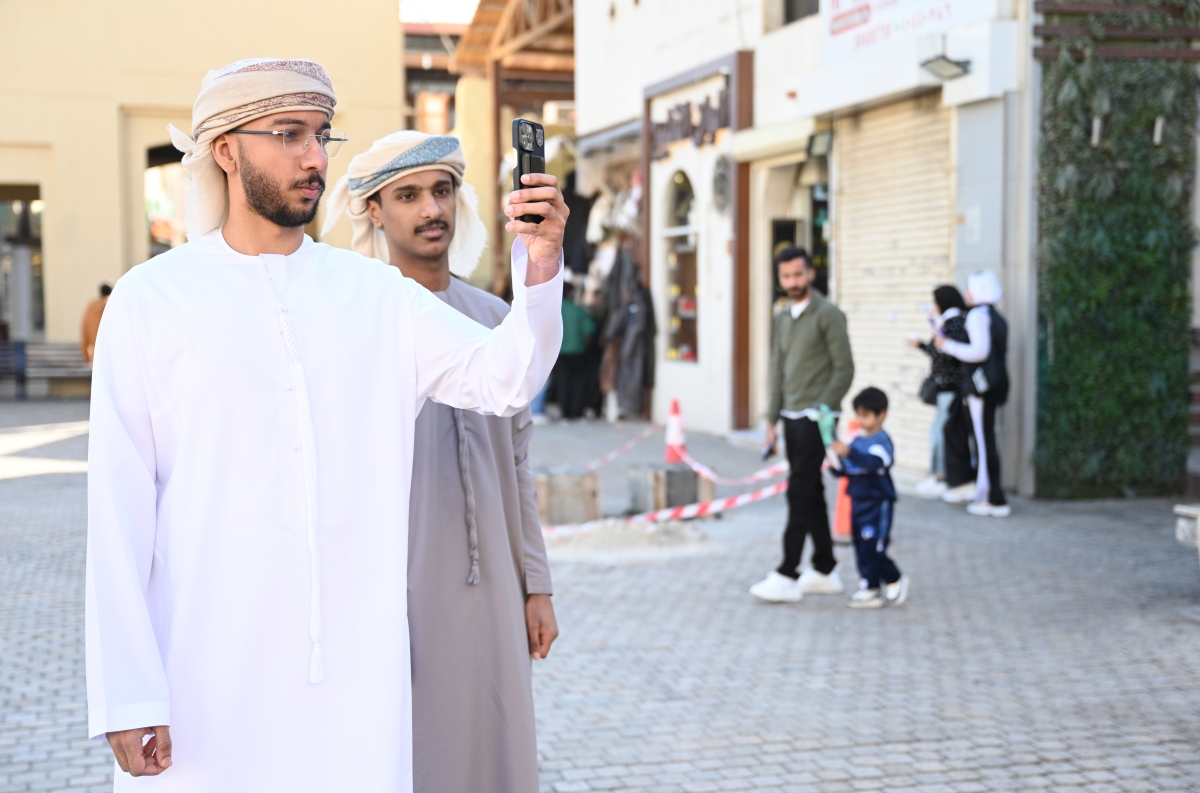 زائران إماراتيان يلتقطان صورة في السوق (تصوير نايف العقلة)
