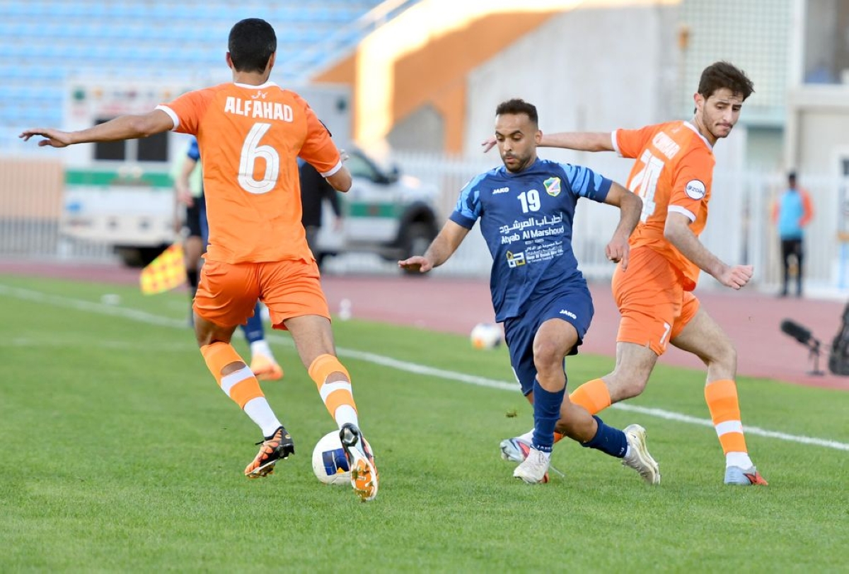 لاعب السالمية معاذ الأصيمع يحاول خطف الكرة من أمام لاعبي كاظمة