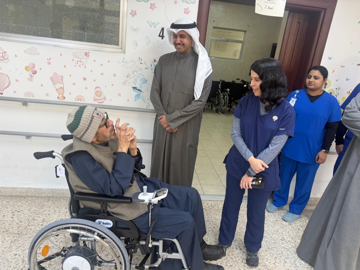 العثمان والهيلع مع أحد المستفيدين بعد استلام كرسيه (تصوير سعود سالم)
