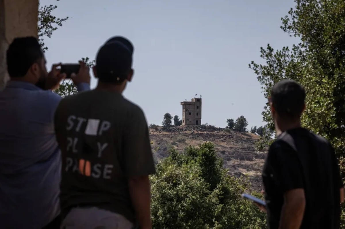 سوريون ينظرون إلى نقطة مراقبة إسرائيلية في القنيطرة