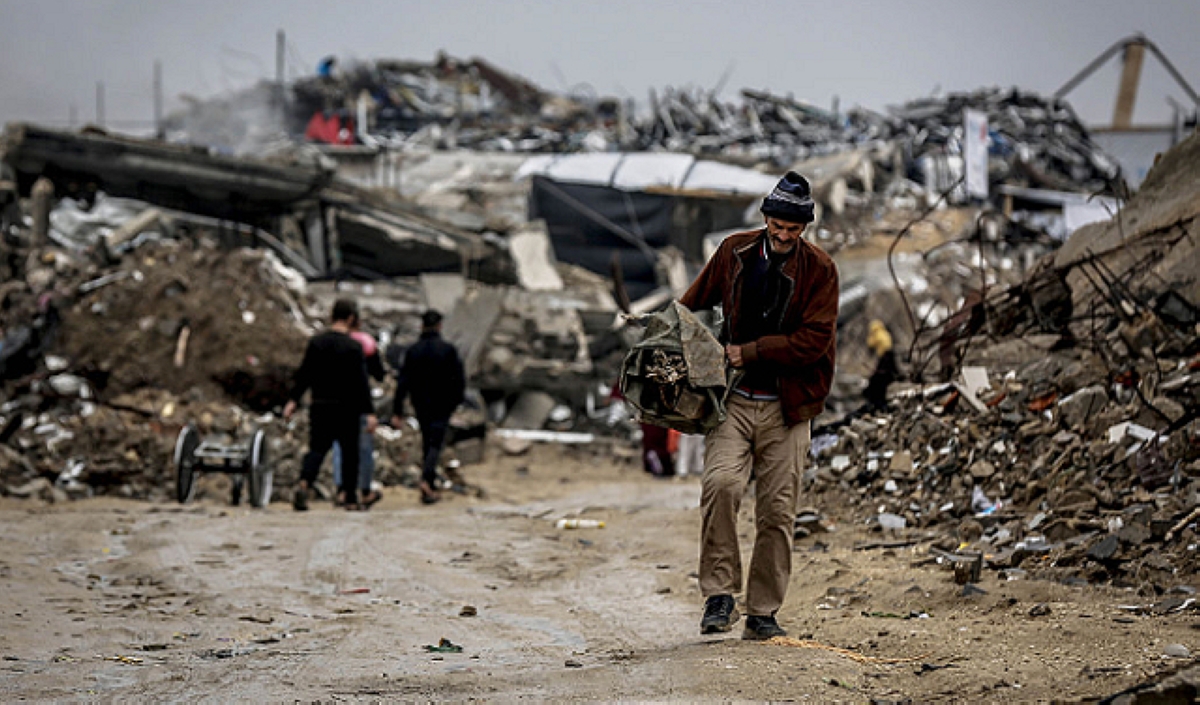 فلسطيني نازح يسير وسط الركام في غزة