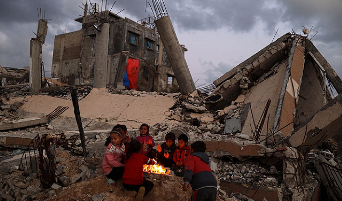 أطفال نازحون يتجمعون حول نار الحطب للتدفئة في غزة