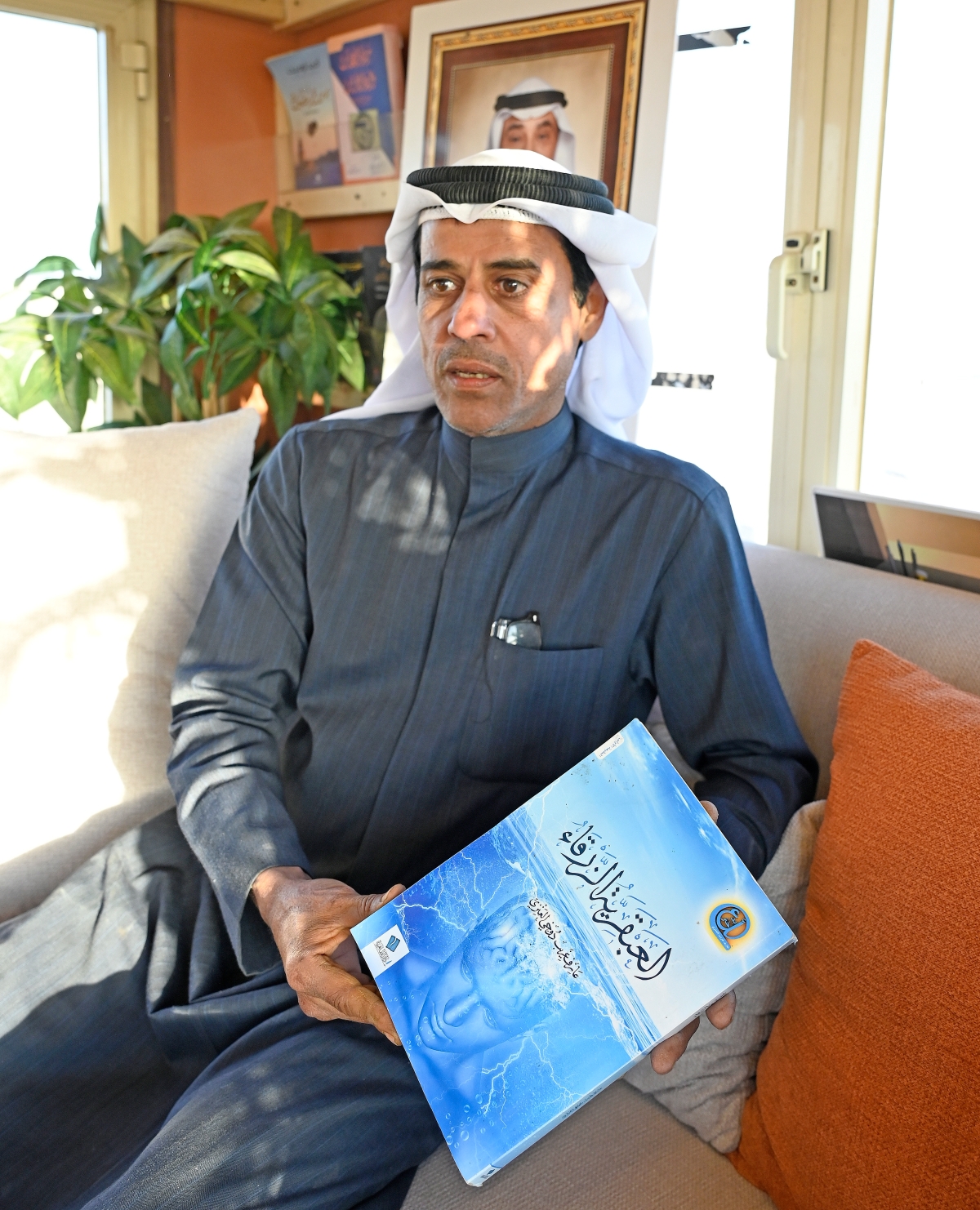 العنزي يعرض كتاباً من تأليفه