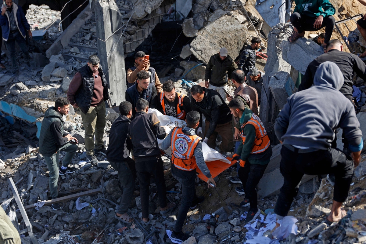 فلسطينيون ينقلون إحدى ضحايا الغارات على حي الشيخ رضوان في غزة (أ ف ب)