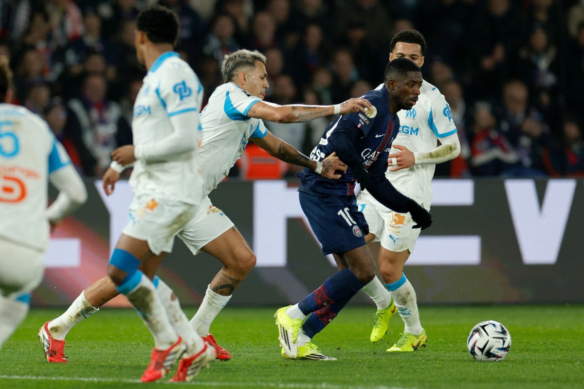 عثمان ديمبيلي متخطياً لاعبي مرسيليا (أ ف ب)