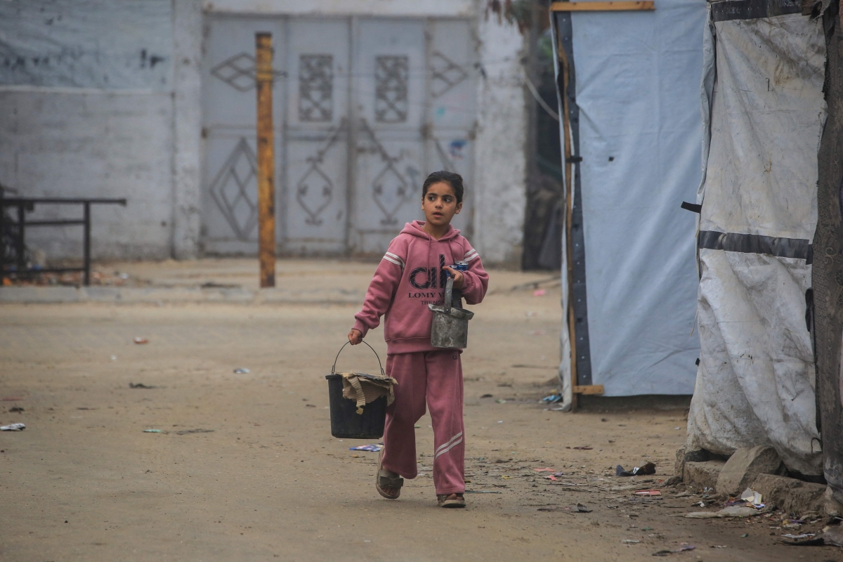 طفلة نازحة تسير بين خيام موقتة في خان يونس (أ ف ب)