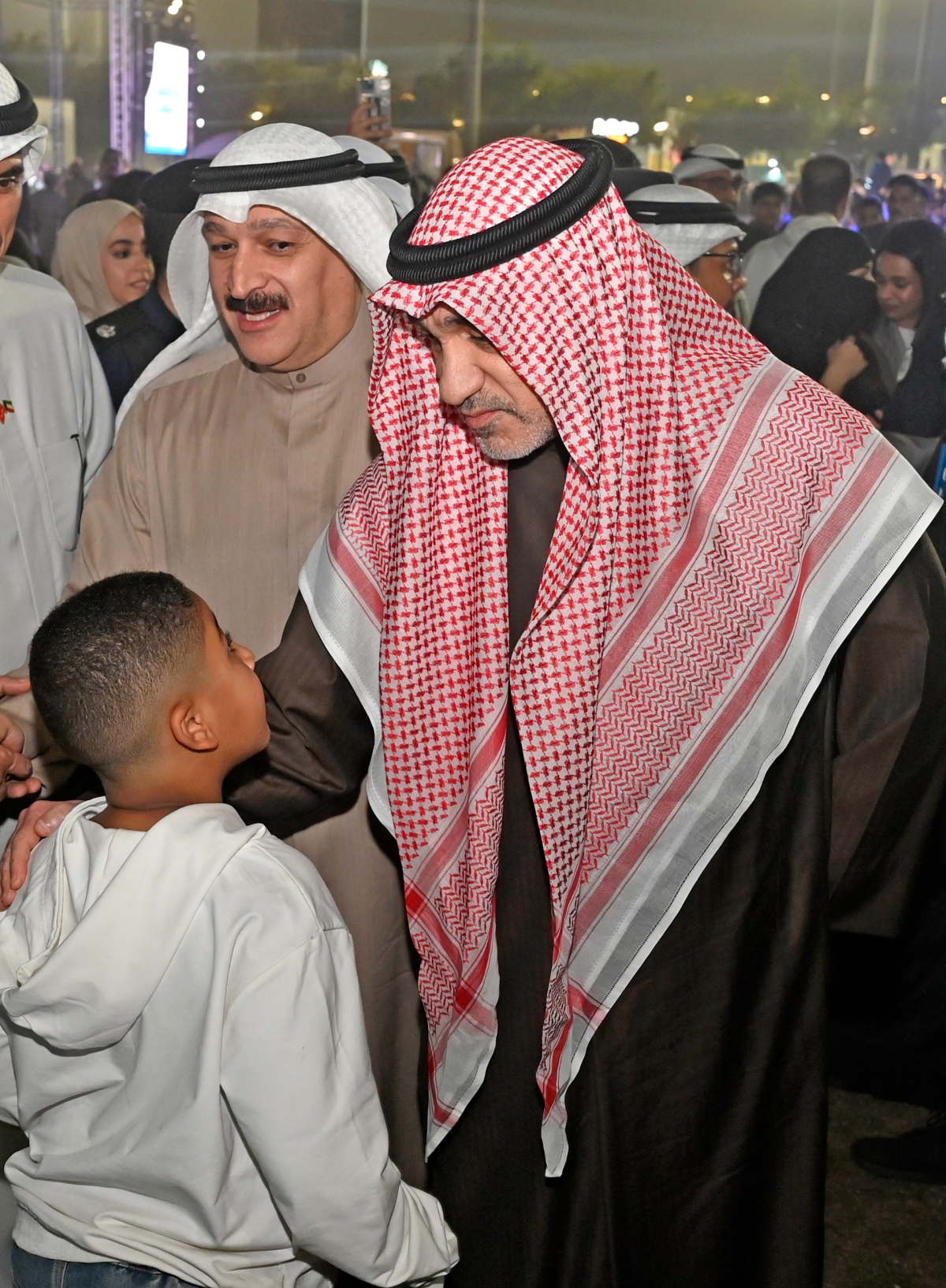 فهد اليوسف ود. أحمد العوضي مع أحد الأطفال 