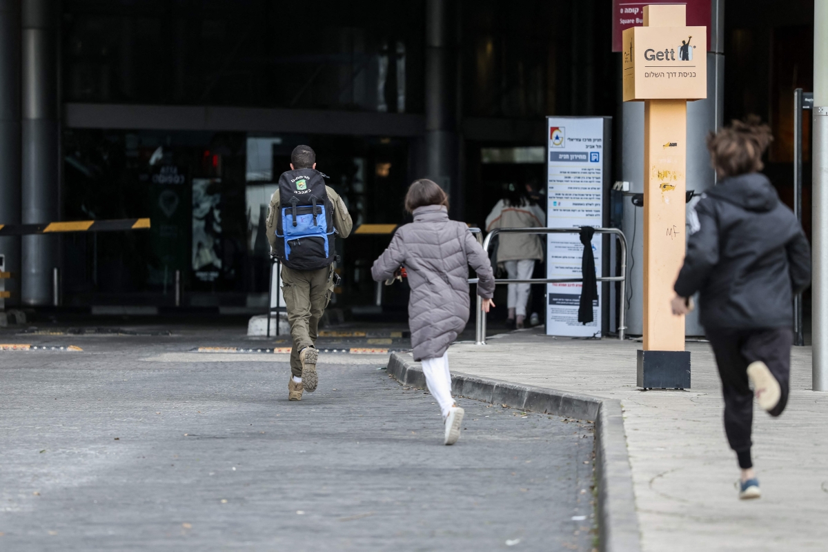 إسرائيليون يهربون إلى الملاجئ بعد سماع صفارات إنذار في تل أبيب (أ ف ب)