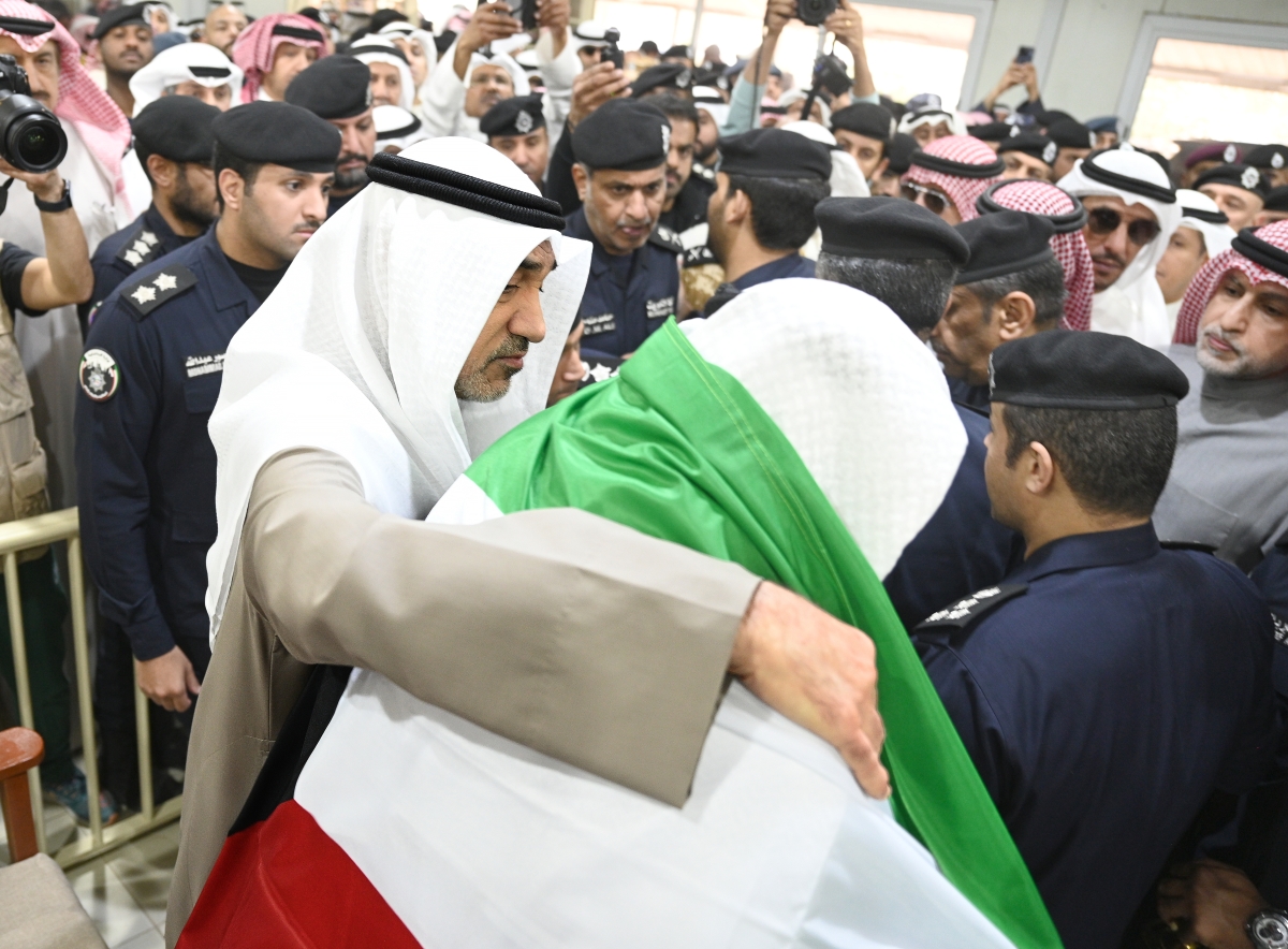 ويضع العلم على كتفي والد الشهيد الثاني