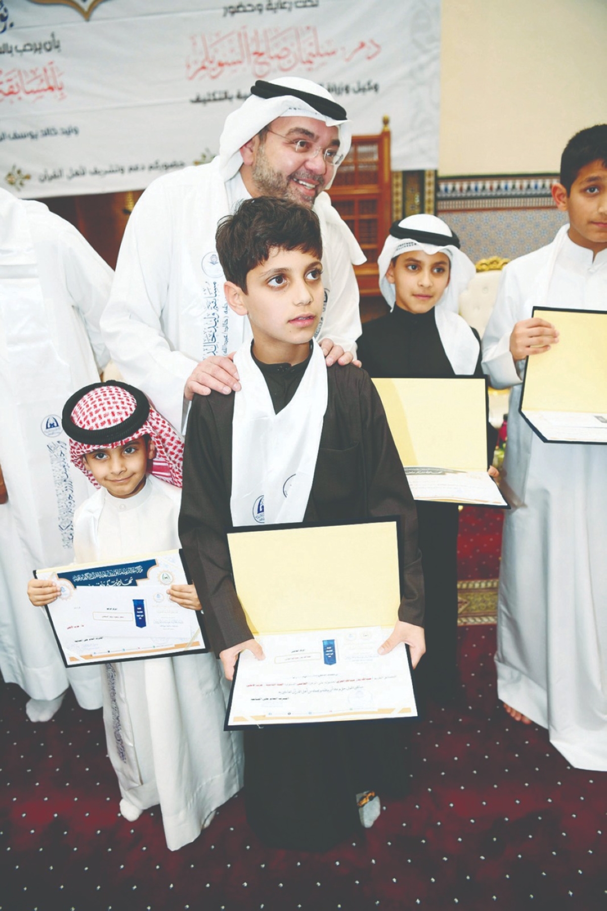 يوسف خالد المرزوق مع عدد من الأطفال الفائزين