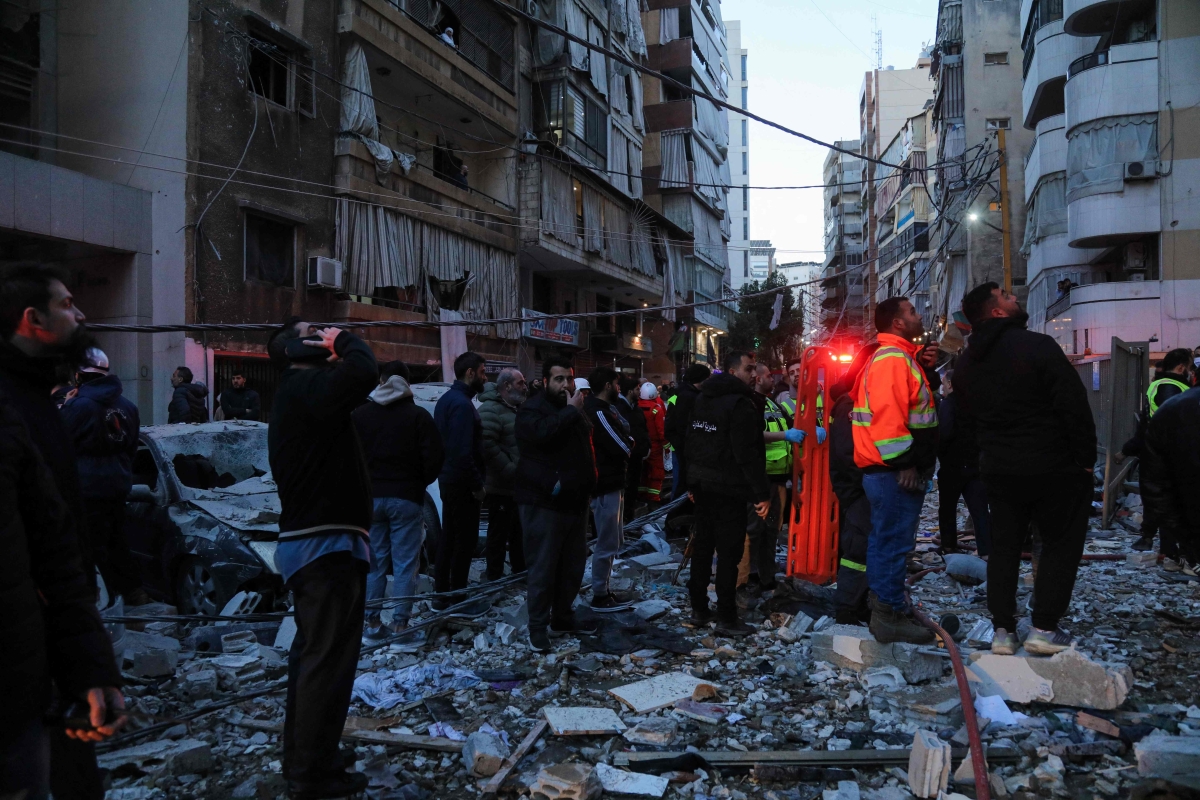 عناصر من الأمن والدفاع المدني تتفقد موقع غارة إسرائيلية على منطقة عائشة بكار وسط بيروت (أ ف ب)