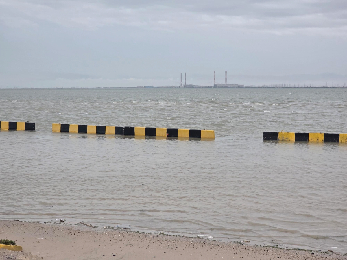 مياه البحر تتجاوز الحاجز الأسمنتي على الشاطئ