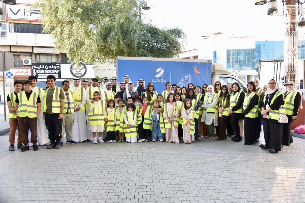 موظفو البنك وفريق المتطوعين وأبنائهم خلال توزيع وجبات إفطار صائم بالتعاون مع البنك الكويتي للطعام والإغاثة