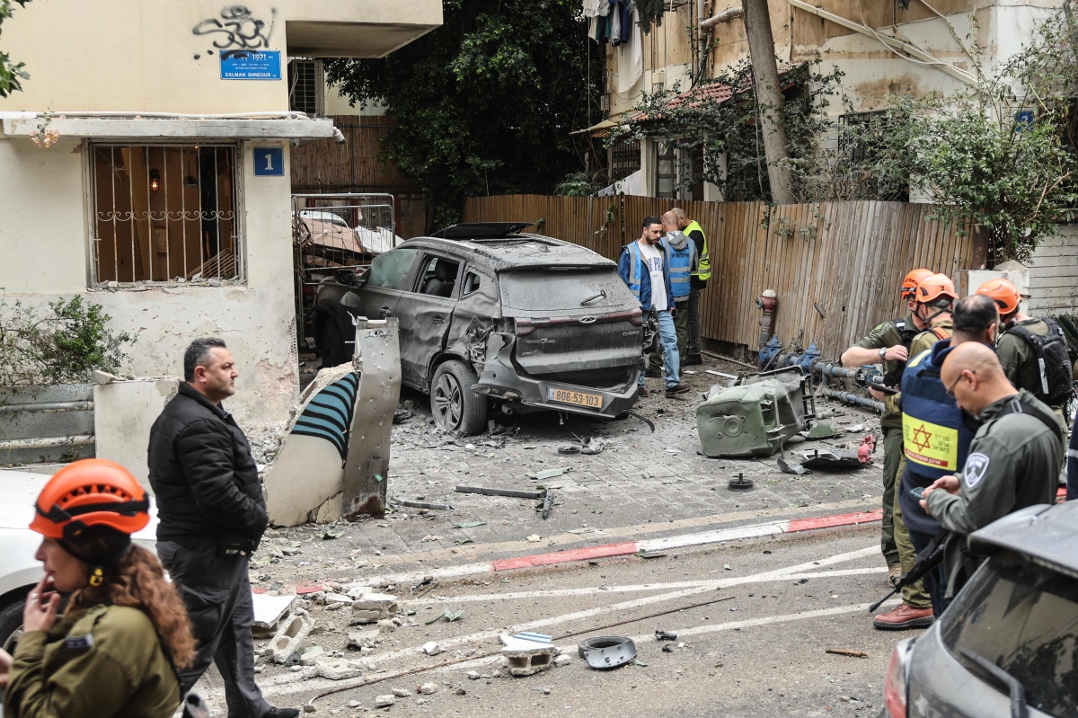 عناصر من الدفاع المدني في موقع ضربة إيرانية على تل أبيب (أ ف ب)