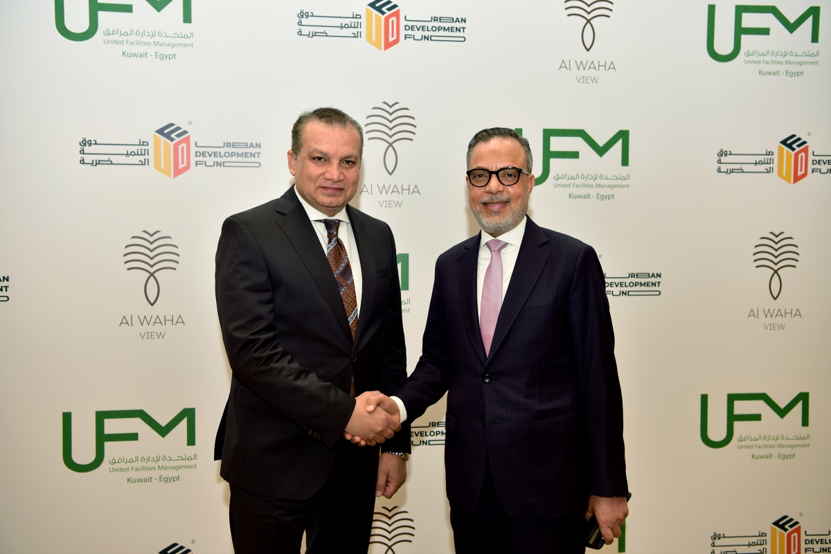 عبداللطيف مصافحاً صديق عقب توقيع اتفاقية الشراكة