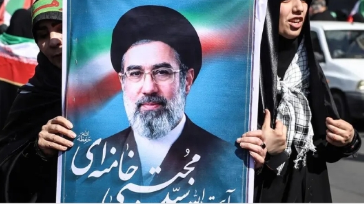 إيرانية تحمل صورة لمجتبى خامنئي في طهران (أرشيفية- أ ف ب)