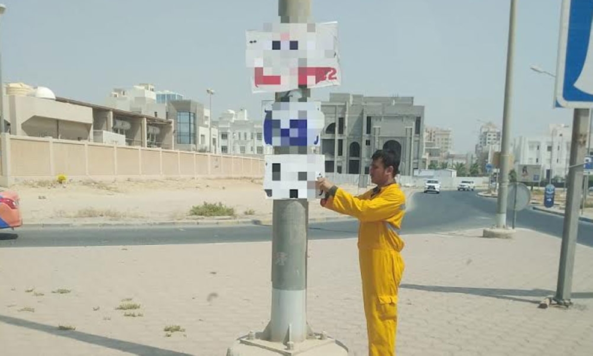 عامل يزيل إعلاناً
