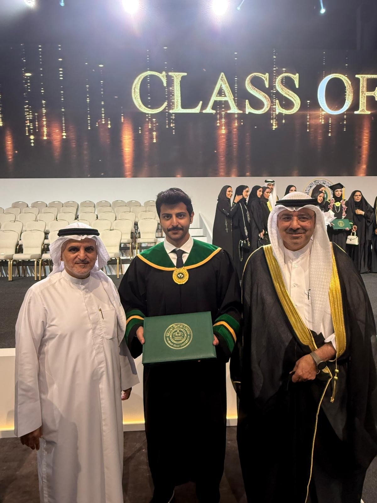 البصيري ورئيس المكتب الثقافي بالبحرين مع أحد الخريجين