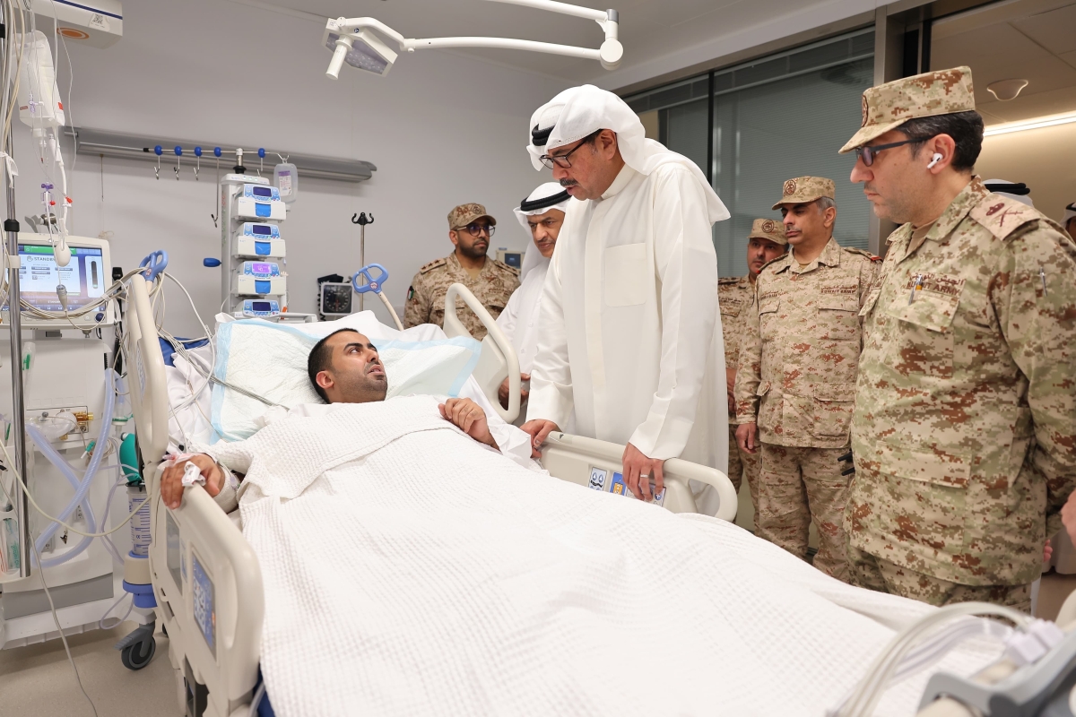 وزير الدفاع مطمئناً على أحد المصابين