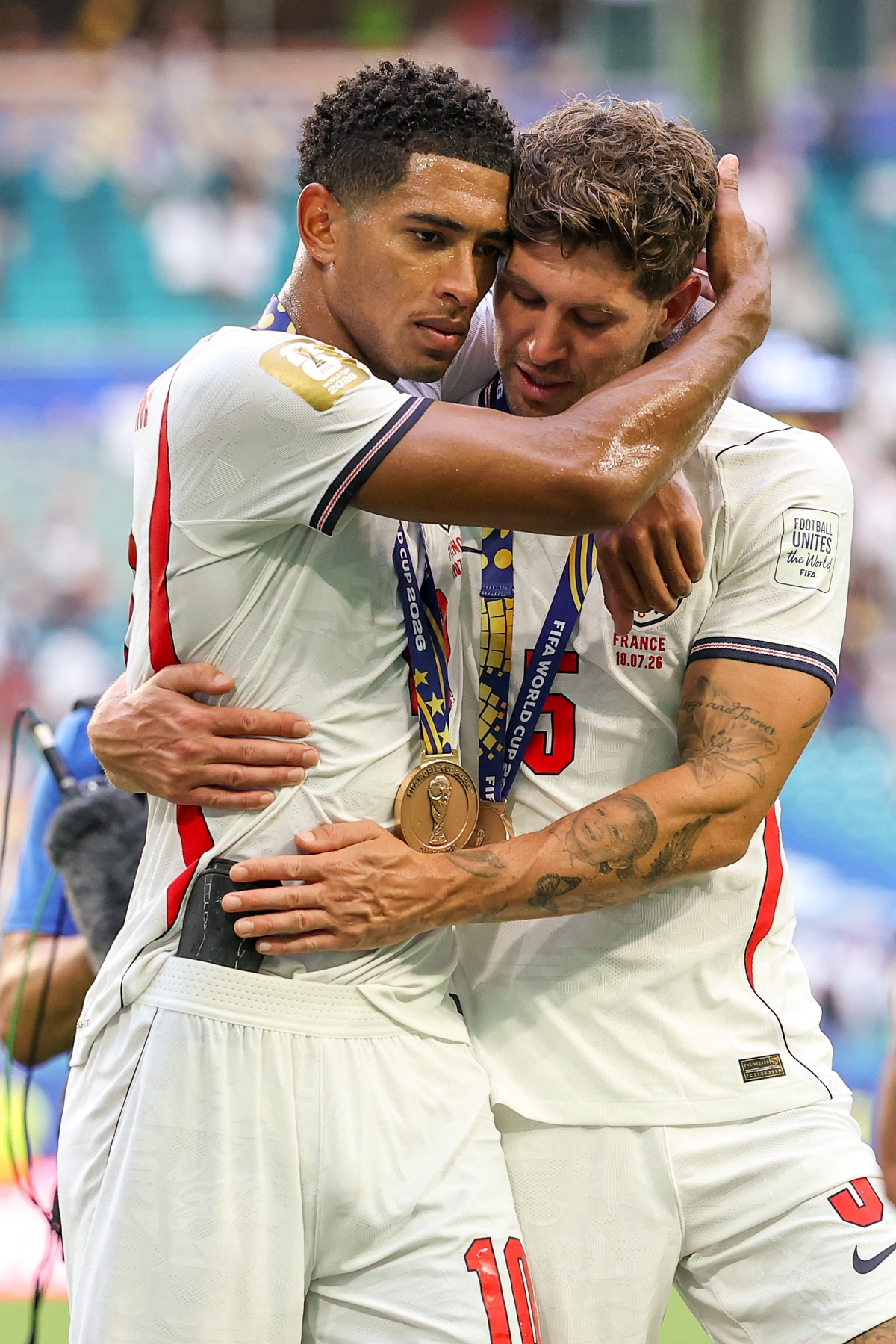 MIAMI GARDENS, FLORIDA - JULY 18: Jude Bellingham #10 and John Stones #5 of England embrace after the 6-4 win during the FIFA World Cup 2026 Bronze Final between France and England at Miami Stadium on July 18, 2026 in Miami Gardens, Florida.   Buda Mendes/Getty Images/AFP (Photo by Buda Mendes / GETTY IMAGES NORTH AMERICA / Getty Images via AFP)