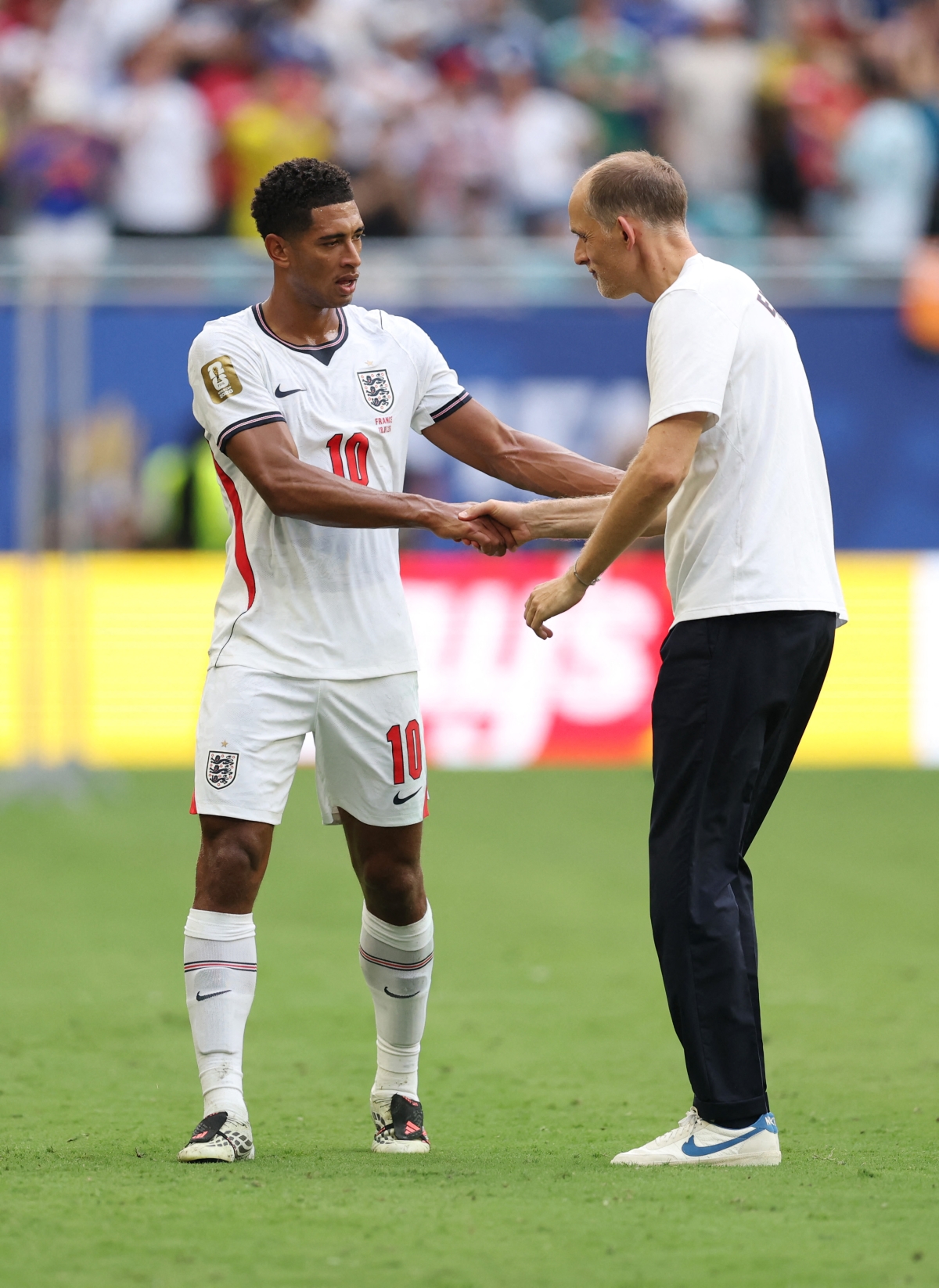 MIAMI GARDENS, FLORIDA - JULY 18: Jude Bellingham #10 of England celebrates with Thomas Tuchel, Head Coach of England after the 6-4 win during the FIFA World Cup 2026 Bronze Final between France and England at Miami Stadium on July 18, 2026 in Miami Gardens, Florida.   Luke Hales/Getty Images/AFP (Photo by Luke Hales / GETTY IMAGES NORTH AMERICA / Getty Images via AFP)